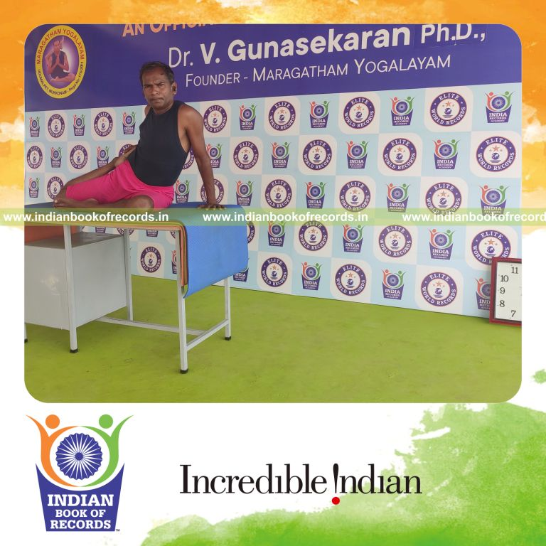 individual holding daksina ardha vamadevasana yoga pose on a table for record in Indian Book of Records
