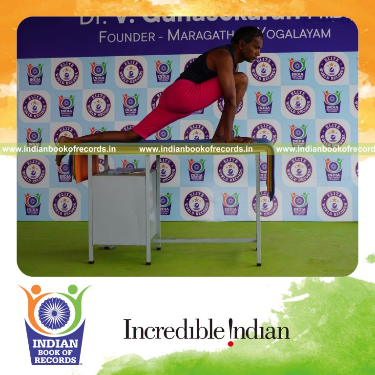 individual holding daksina asva chanjalanasana yoga pose on a table for record in Indian Book of Records