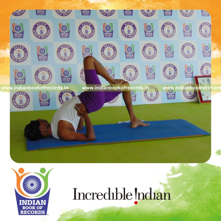 individual holding daksina ekapada janu setu bandha sarvangasana yoga pose blindfolded for record in Indian Book of Records