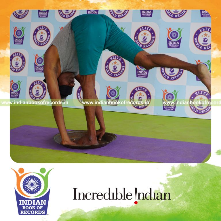 individual holding daksina ekapada padahasthasana yoga pose blindfolded on a brass plate for record in Indian Book of Records
