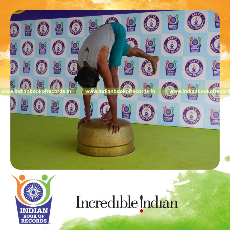 individual holding daksina ekapada padahasthasana yoga pose blindfolded on a vessel for record in Indian Book of Records