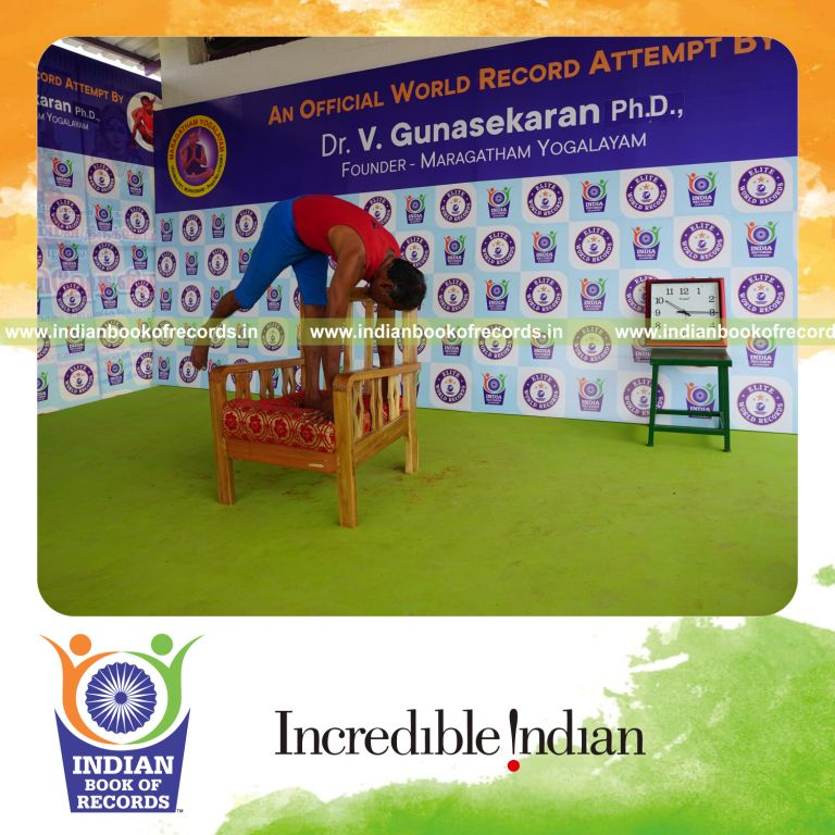 individual holding daksina ekapada padahasthasana yoga pose on a chair for record in Indian Book of Records