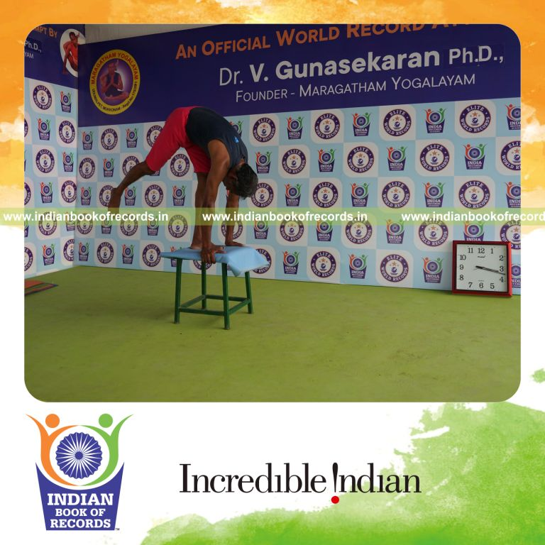 individual holding daksina ekapada padahasthasana yoga pose on a stool for record in Indian Book of Records