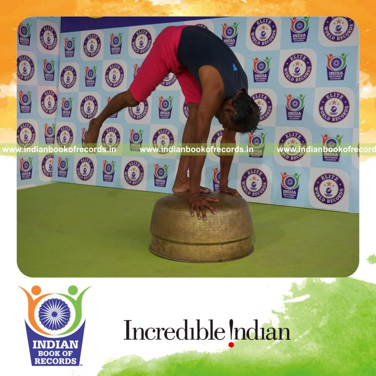 individual holding daksina ekapada padahasthasana yoga pose on a vessel for record in Indian Book of Records