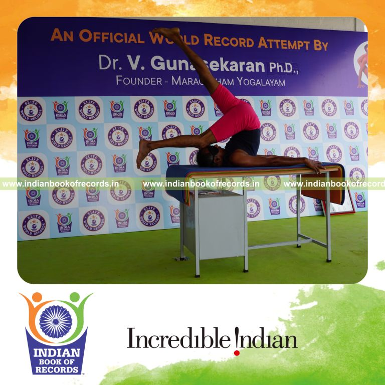 individual holding daksina ekapada salamba sarvangasana yoga pose blindfolded on a table for record in Indian Book of Records