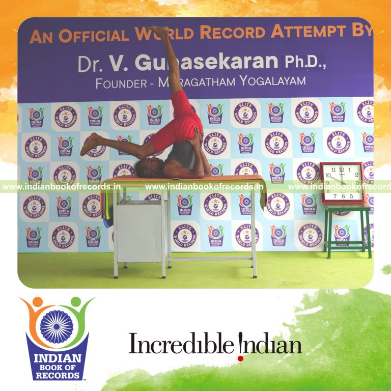 individual holding daksina ekapada sarvangasana yoga pose on a table for record in Indian Book of Records