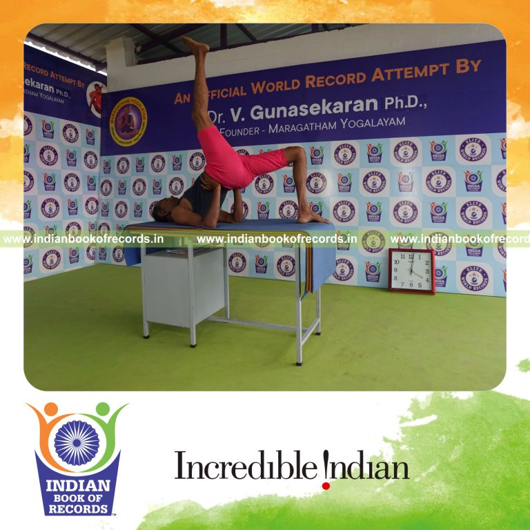 individual holding daksina ekapada setu bandha sarvangasana yoga pose on a table for record in Indian Book of Records