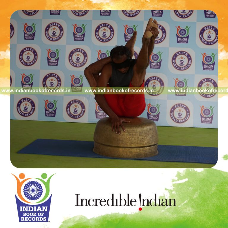individual holding daksina ekapada sirasa krounchasana yoga pose blindfolded on a vessel for record in Indian Book of Records