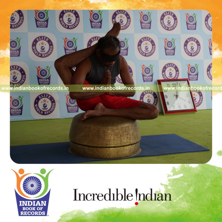 individual holding daksina ekapada sirsasana yoga pose blindfolded on a vessel for record in Indian Book of Records