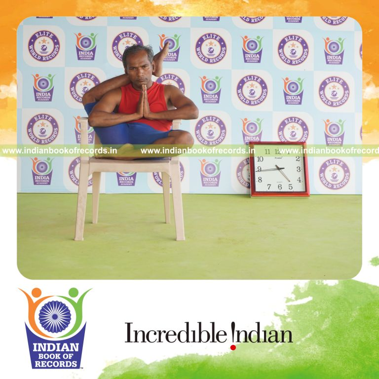 individual holding daksina ekapada sirsasana yoga pose on a chair for record in Indian Book of Records