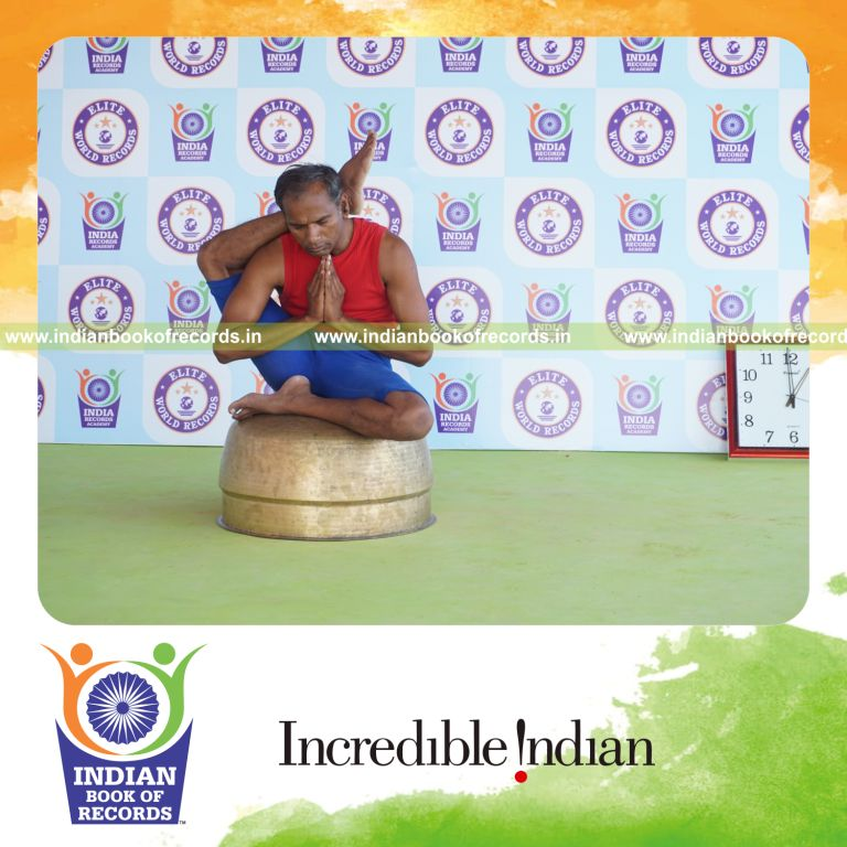 individual holding daksina ekapada sirsasana yoga pose on a vessel for record in Indian Book of Records