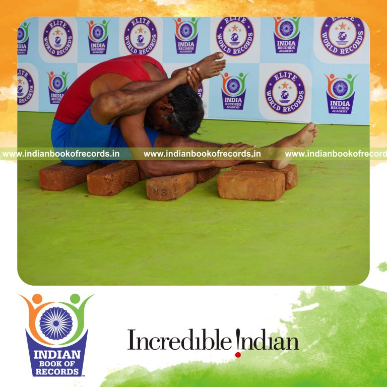 individual holding daksina ekapada skandasana yoga pose on bricks for record in Indian Book of Records