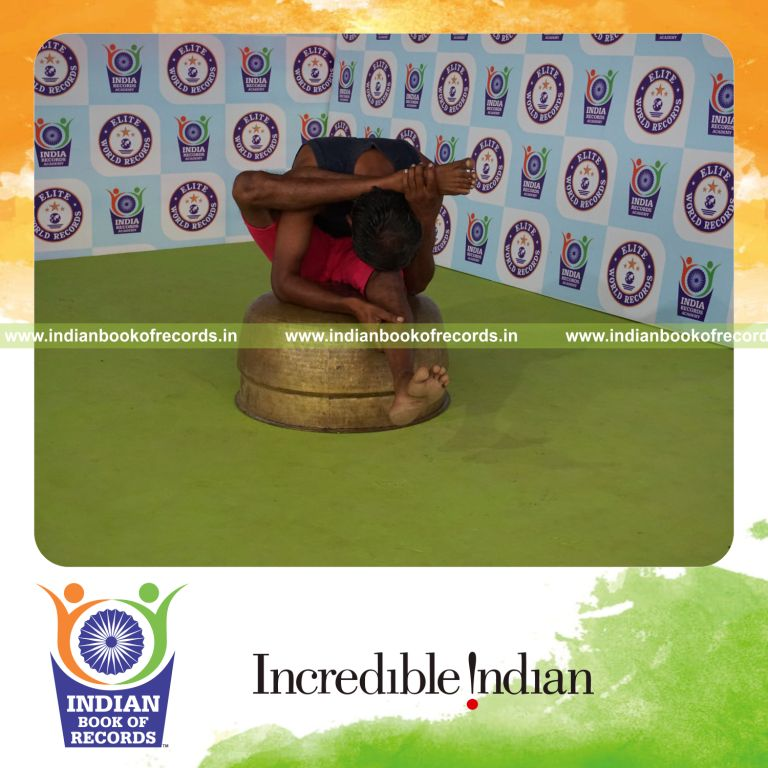 individual holding daksina ekapada skandasana yoga pose on a vessel for record in Indian Book of Records
