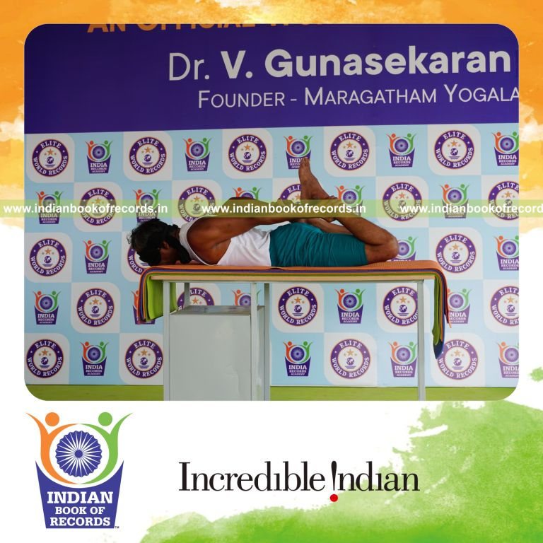 individual holding daksina gherandasana first type yoga pose blindfolded on a table for record in Indian Book of Records