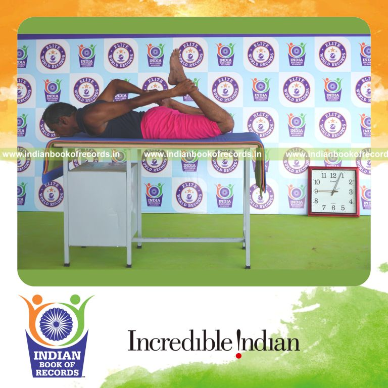 an individual holding daksina gherandasana first type yoga pose on a table for the longest duration with strength and balance for a record in Indian Book of Records