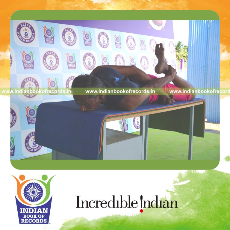 an individual holding daksina gherandasana second type yoga pose on a table for the longest duration with control and stability for a record in Indian Book of Records