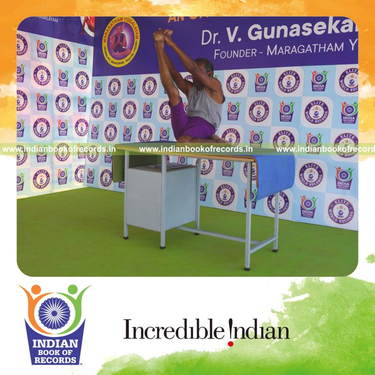 individual holding daksina gomukha krounchasana yoga pose on a table for record in Indian Book of Records