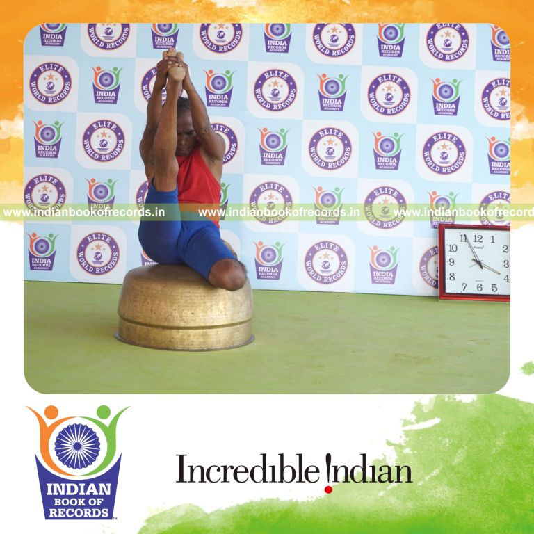 individual holding daksina gomukha krounchasana yoga pose on a vessel for record in Indian Book of Records