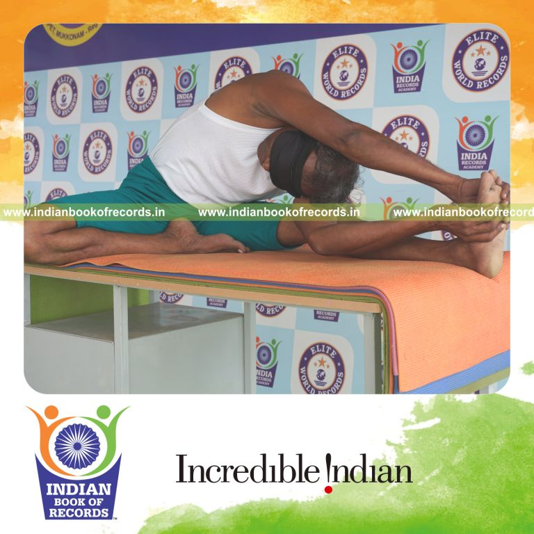an individual holding daksina janu parivrtta ardha matsyendrasana yoga pose blindfolded on a table continuously for the longest duration with balance and control for a record in Indian Book of Records
