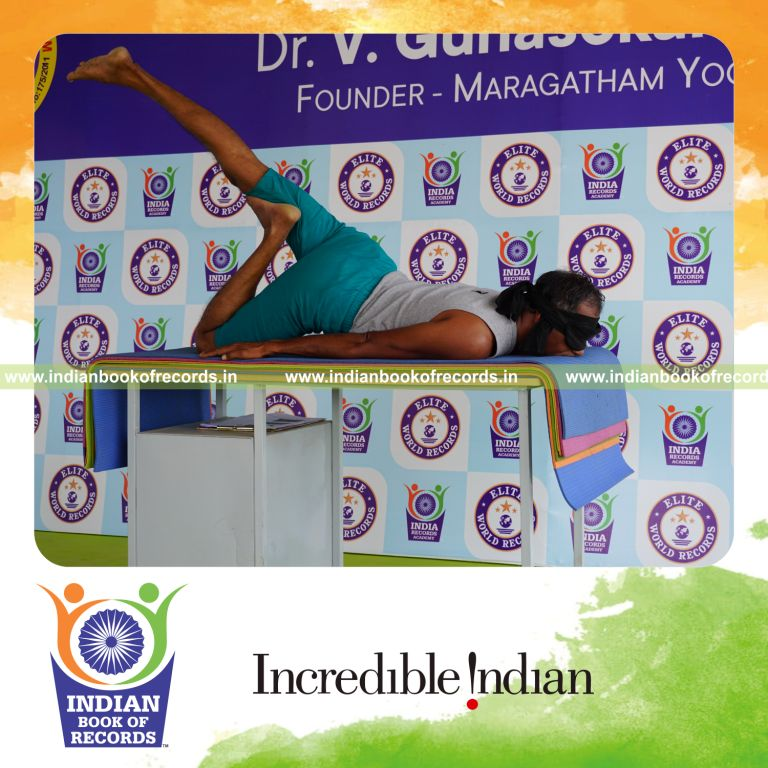 individual holding daksina janu salabhasana yoga pose blindfolded on a table for record in Indian Book of Records