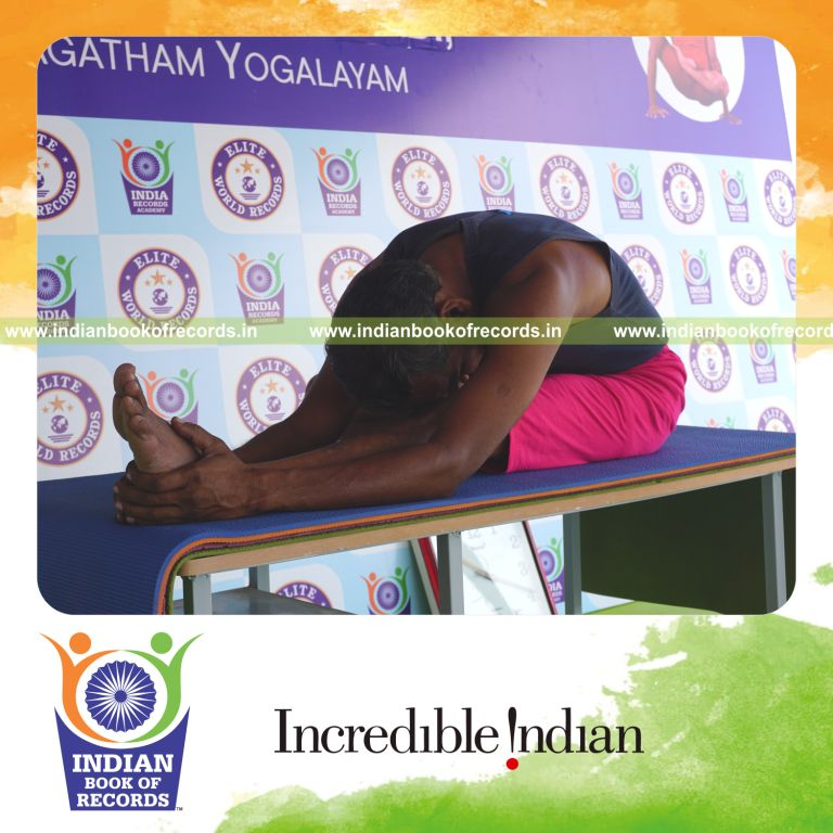 an individual holding daksina janu sirsasana yoga pose on a table for the longest duration with flexibility and control for a record in Indian Book of Records