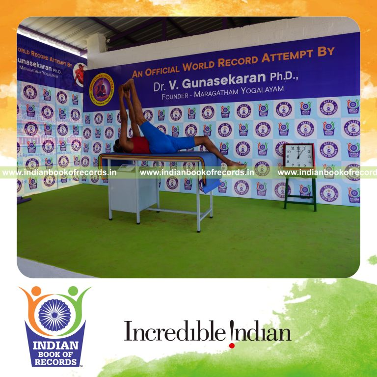 individual holding daksina julasana yoga pose blindfolded on a table for record in Indian Book of Records