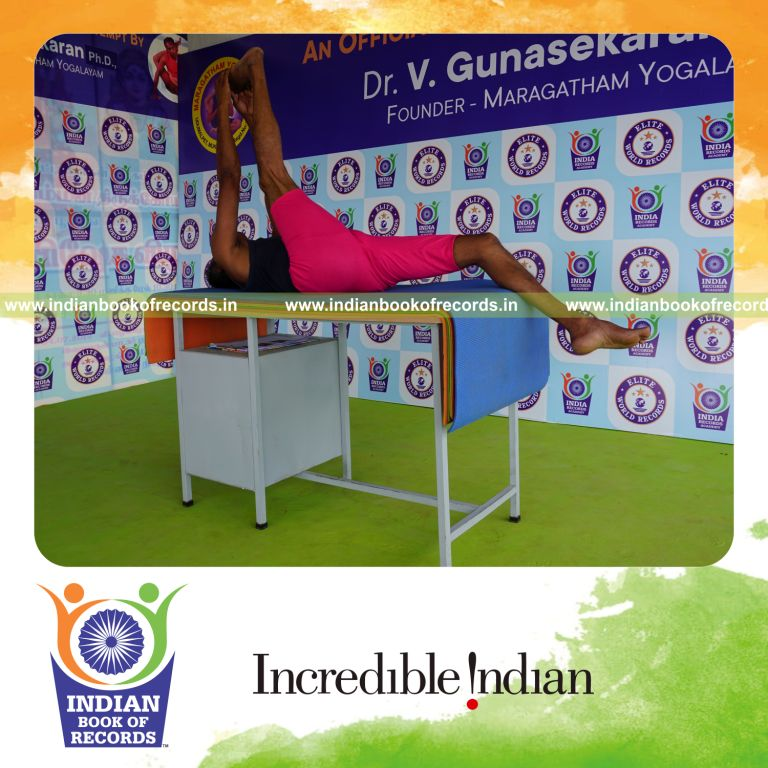 individual holding daksina julasana yoga pose on a table for record in Indian Book of Records