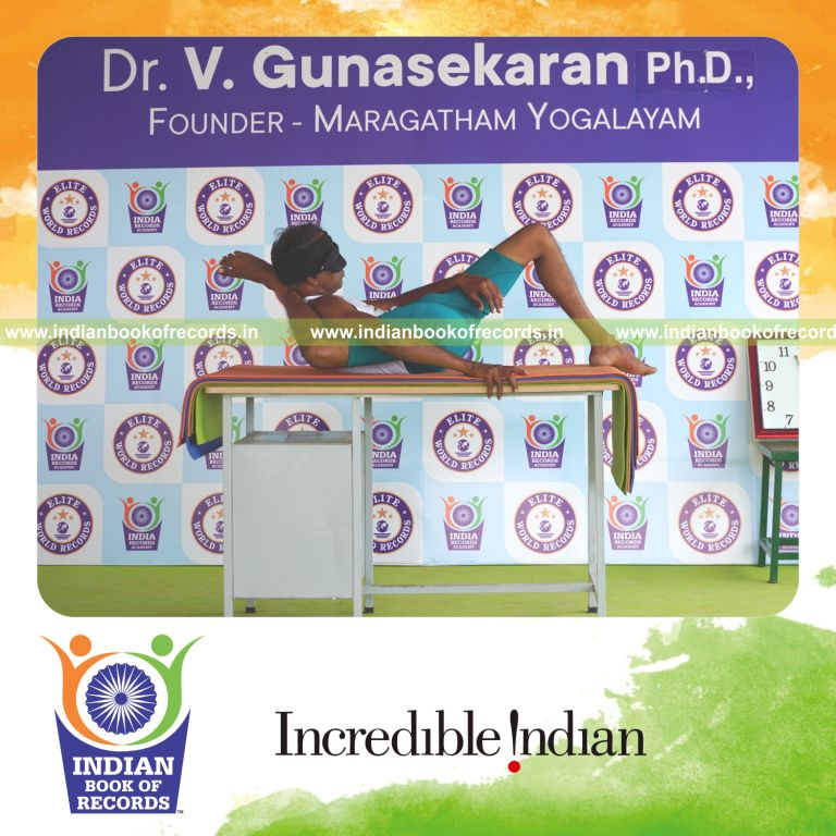 an individual holding daksina kala bhairavasana yoga pose blindfolded on a table continuously for the longest duration with control and balance for a record in Indian Book of Records