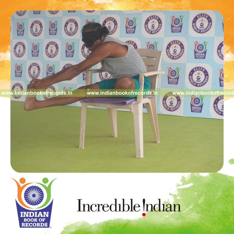 individual holding daksina mahamudra yoga pose blindfolded on a chair for record in Indian Book of Records