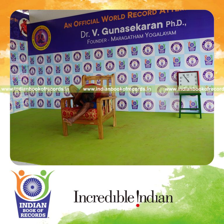 individual holding daksina marichyasana yoga pose on a chair for record in Indian Book of Records