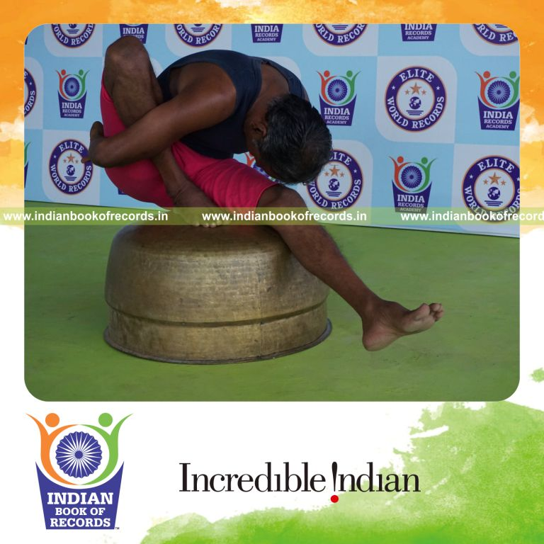 individual holding daksina marichyasana yoga pose on a vessel for record in Indian Book of Records