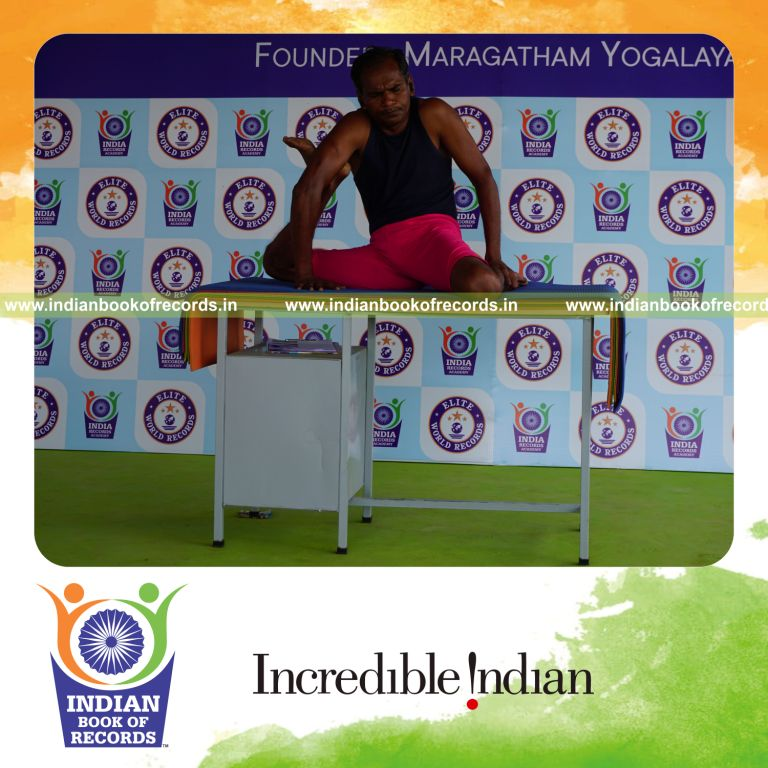individual holding daksina mrigasana yoga pose on a table for record in Indian Book of Records