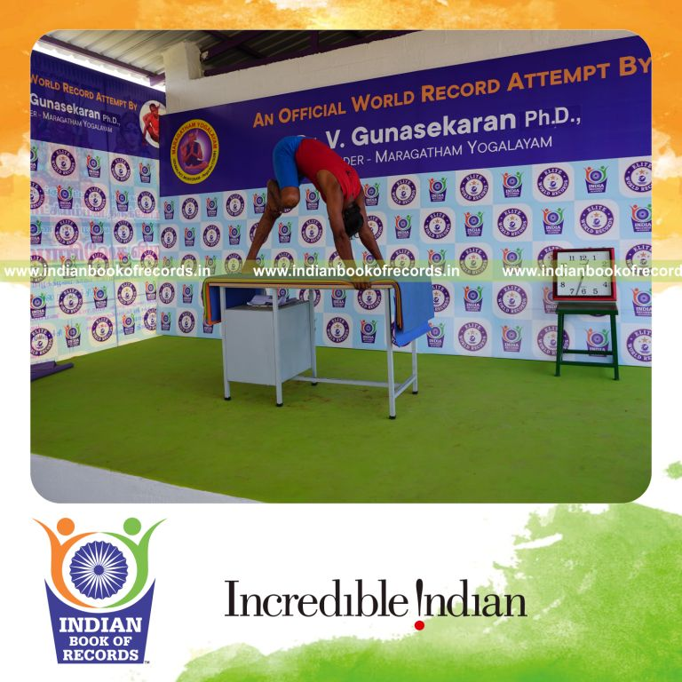 individual holding daksina nasika prusta janu parsavasana yoga pose blindfolded on a table for record in Indian Book of Records