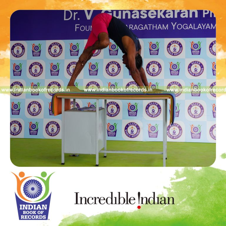 individual holding daksina nasika prusta janu parsavasana yoga pose on a table for record in Indian Book of Records