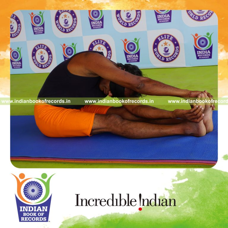 individual holding daksina parivrtana janu sirsasana yoga pose blindfolded for record in Indian Book of Records