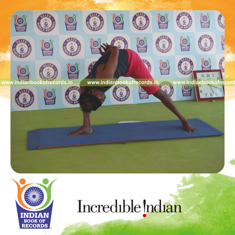 individual holding daksina parivrtana parsva konasana yoga pose blindfolded for record in Indian Book of Records