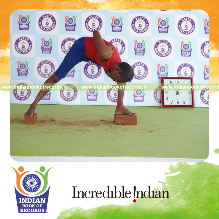 individual holding daksina parivrtana parsva konasana yoga pose on bricks for record in Indian Book of Records