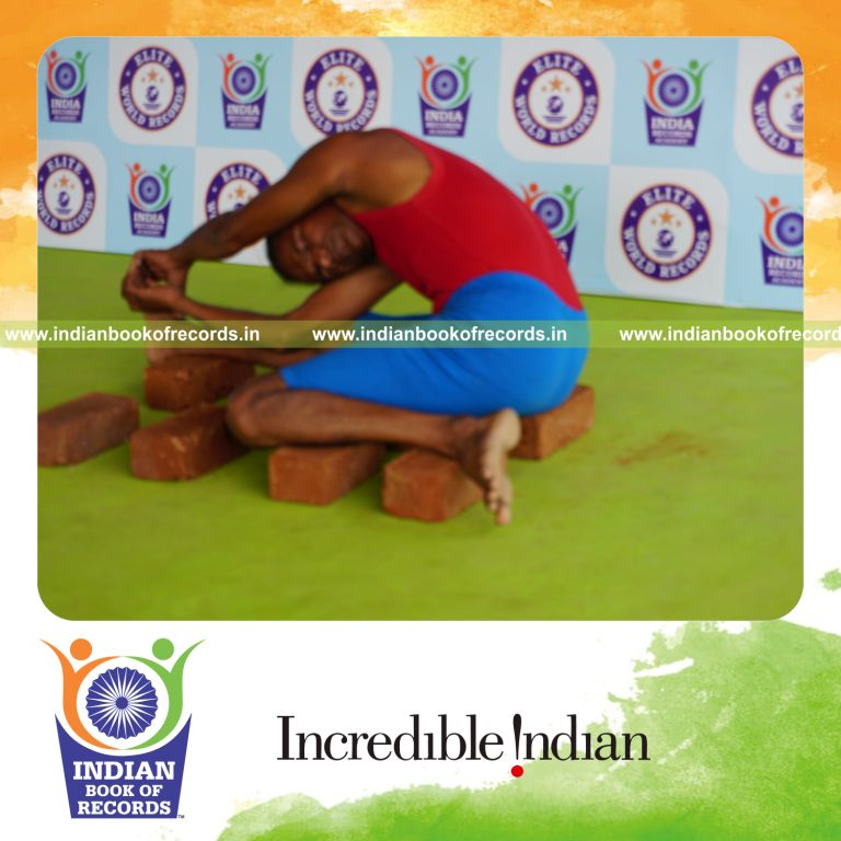 individual holding daksina parivrtta gomukha janu sirsasana yoga pose on bricks for record in Indian Book of Records
