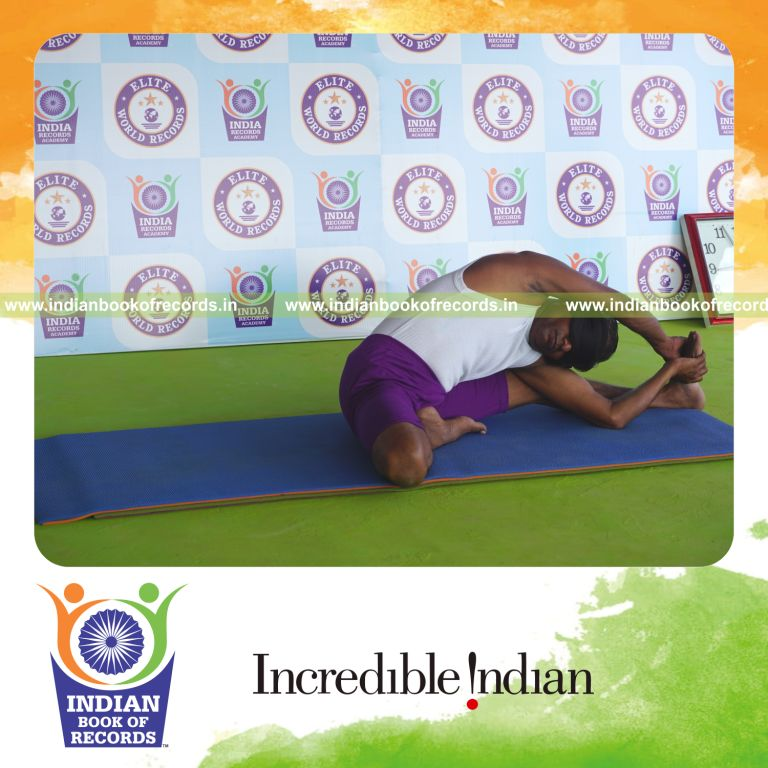 individual holding daksina parivrtta janu sirsasana yoga pose blindfolded for record in Indian Book of Records