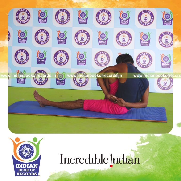 an individual holding daksina parivrtta marichyasana yoga pose blindfolded for the longest duration with flexibility and control for a record in Indian Book of Records