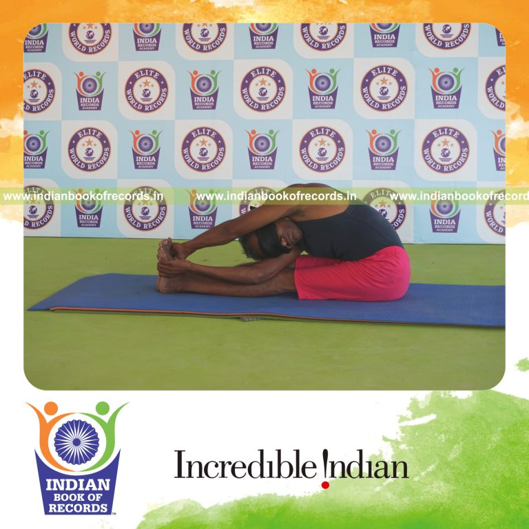 individual holding daksina parivrtta paschimottanasana yoga pose blindfolded for record in Indian Book of Records