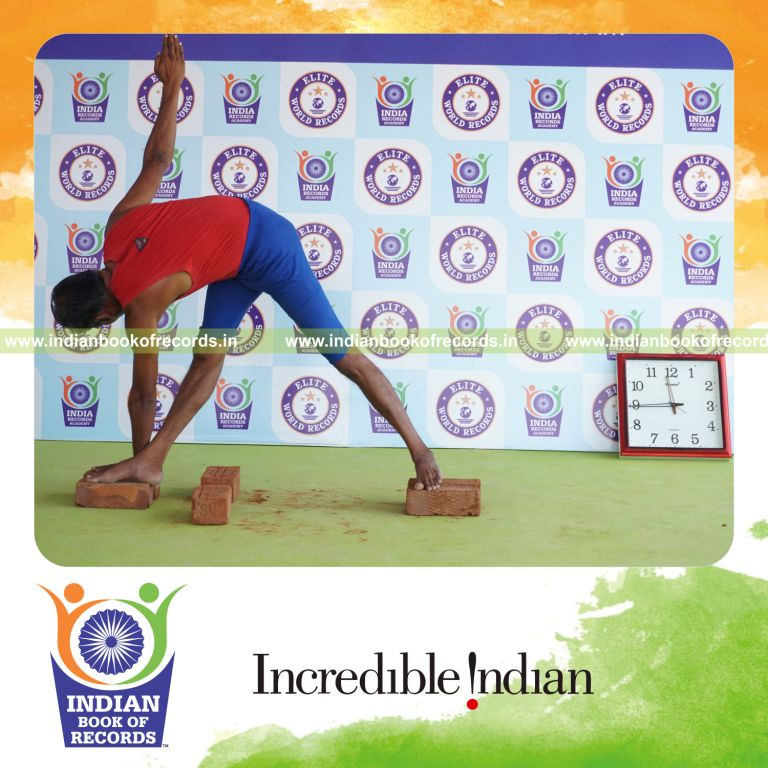 individual holding daksina parivrtta trikonasana yoga pose on bricks for record in Indian Book of Records