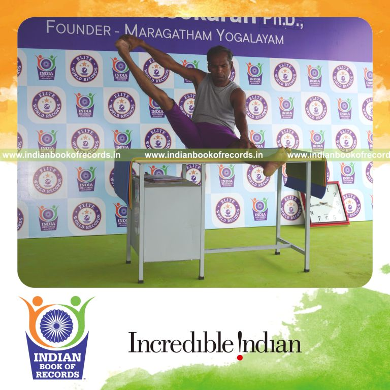 individual holding daksina parsva akarna dhanurasana yoga pose on a table for record in Indian Book of Records