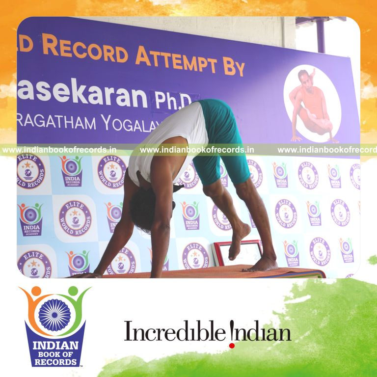 an individual holding daksina parsva ekapada adho mukha svanasana yoga pose blindfolded on a table continuously for the longest duration with control and balance for a record in Indian Book of Records
