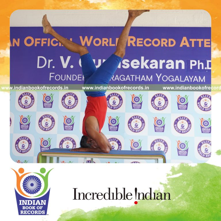 individual holding daksina parsva ekapada salamba sirsasana yoga pose on a table for record in Indian Book of Records