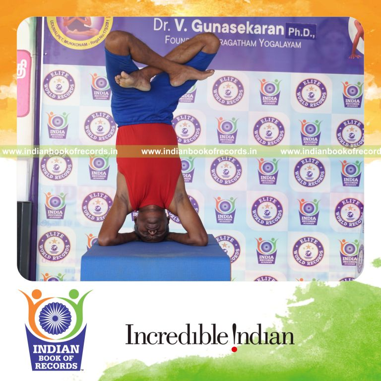 individual holding daksina parsva padma salamba sirsasana yoga pose on a table for record in Indian Book of Records