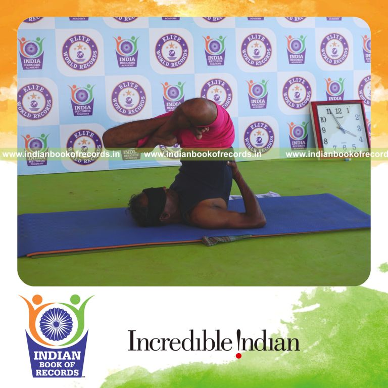 an individual holding daksina parsva padma sarvangasana yoga pose blindfolded for the longest duration with balance and stability for a record in Indian Book of Records