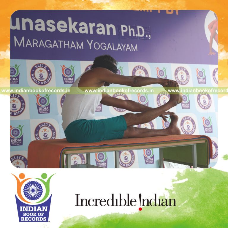an individual holding daksina purna akarna dhanurasana yoga pose blindfolded on a table continuously for the longest duration with stability and control for a record in Indian Book of Records