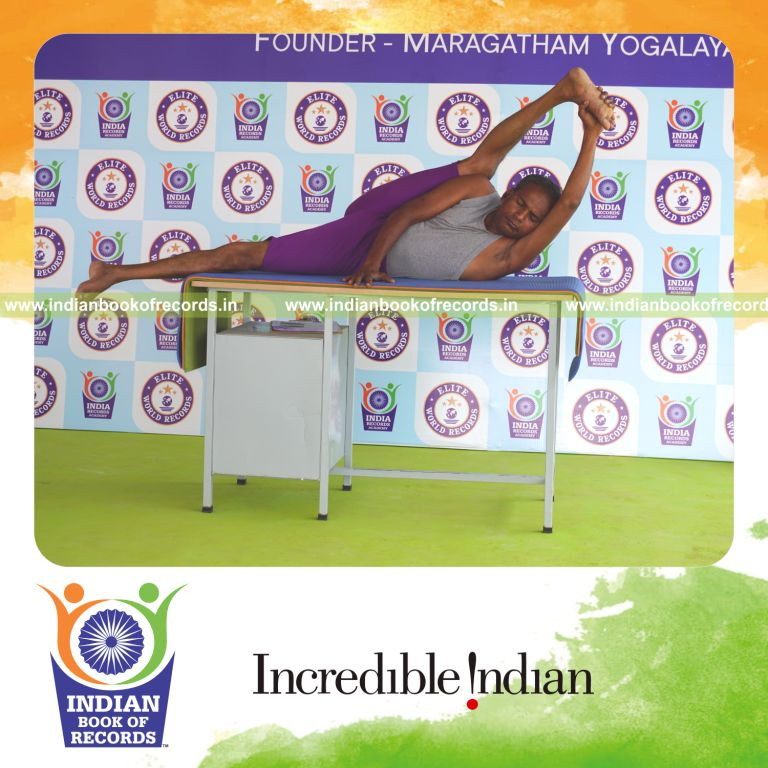individual holding daksina purna anandasana yoga pose on a table for record in Indian Book of Records