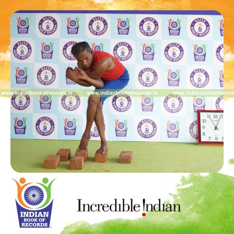 individual holding daksina purna garudasana yoga pose on bricks for record in Indian Book of Records